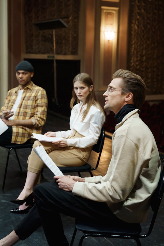 Group of actors engaging in a theater rehearsal indoors.